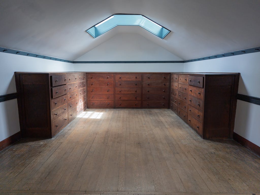 Shaker-style storage room featuring wooden drawers and a skylight, emanating rustic charm.